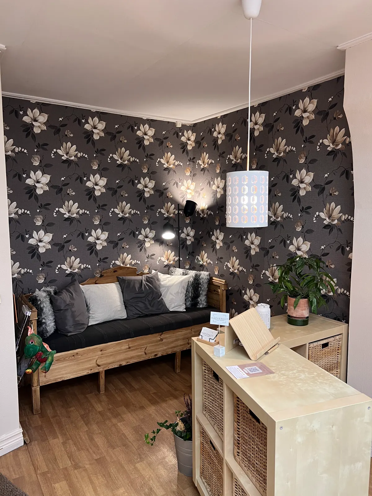 Väntrum med soffa och blommig tapet i salongen Hårverket, Emmaboda